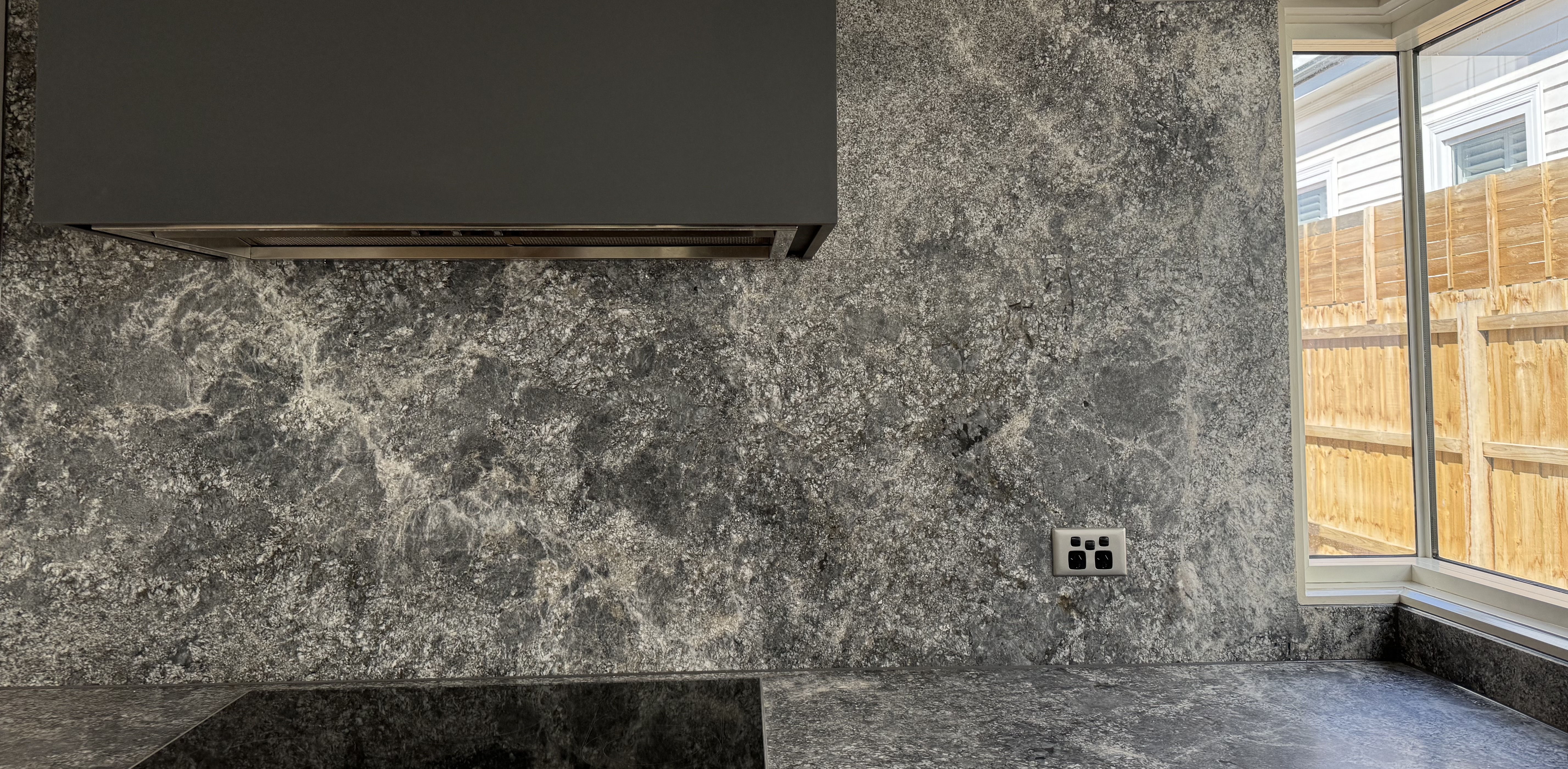 Kitchen — stone splashback and range hood