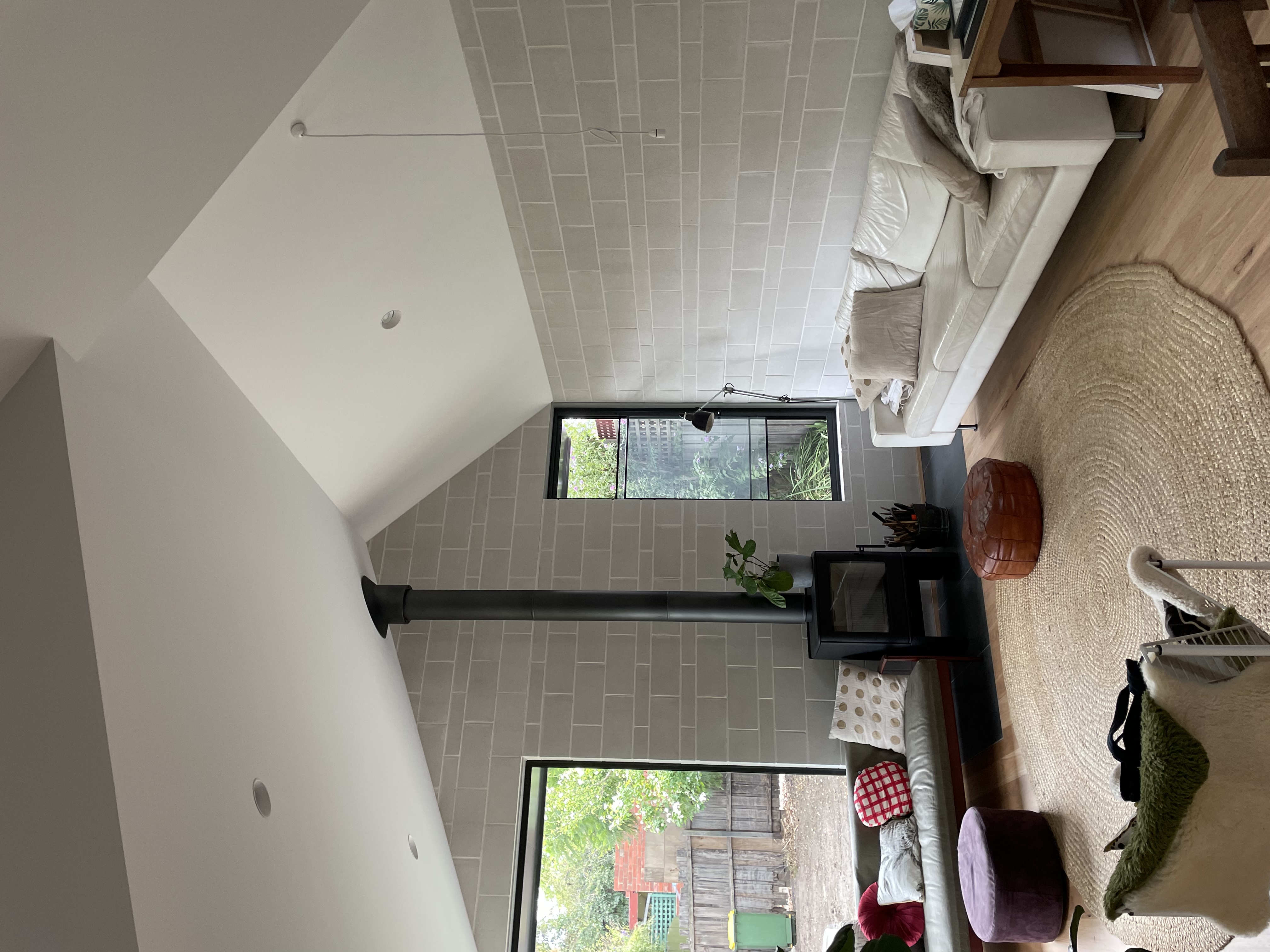 Living room — high ceiling, fireplace, garden view